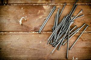 Nails on the table. On a wooden background. photo