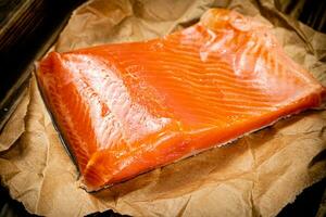 A large piece of salted salmon on a wooden tray. photo