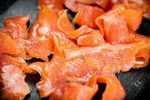 Pieces of salted salmon on a stone board. photo