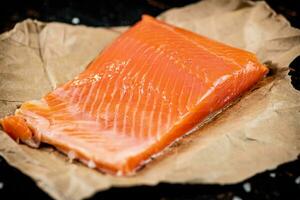 A piece of salted salmon on paper. photo