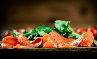 Pieces of salted salmon with parsley on the table. photo