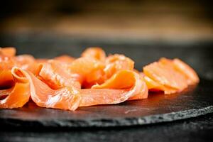 Slices of salted salmon on the table. photo