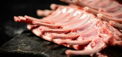 Raw rack of lamb on a cutting board on the table. photo