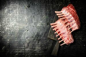 Raw rack of lamb on a cutting board on the table. photo