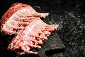 Raw rack of lamb on a cutting board on the table. photo
