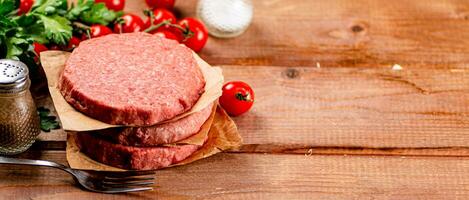 crudo hamburguesa con Fresco Tomates. foto