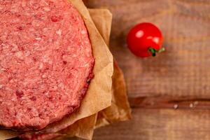 Raw burger with fresh tomatoes. photo