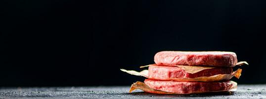 Pile raw burger on the table. photo