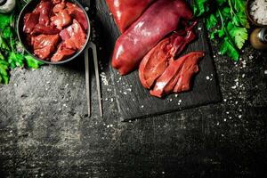 crudo hígado en un Roca tablero con perejil. foto