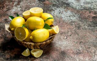 Lemons with leaves in the basket. photo