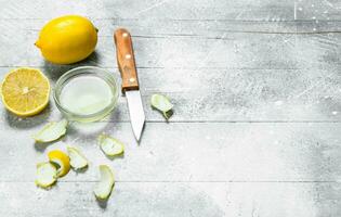 Lemon juice bowl with the zest of a lemon and a knife. photo