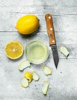 Lemon juice bowl with the zest of a lemon and a knife. photo