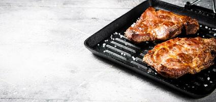 Pork steak in a grill pan. photo