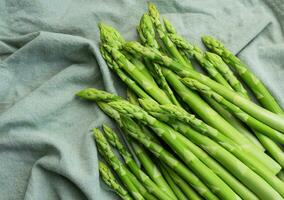 Fresh green asparagus on  textile background. photo