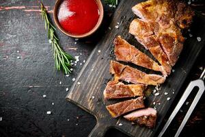 Slices of grilled steak pork on a wooden cutting board. photo