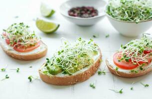 Healthy Eating. Sandwiches with tomatoes, avocado and microgreens. photo