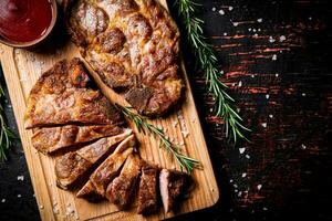 Slices of grilled steak pork on a wooden cutting board. photo