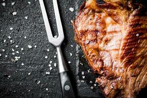 Grilled pork steak with fork. photo