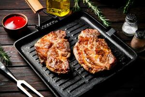 Grilled pork steak in a frying pan. photo