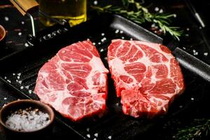 Raw pork steak on a grill pan. photo