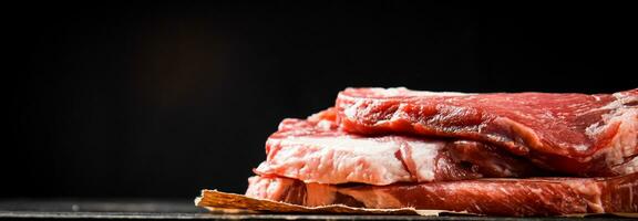 A pile of raw pork steak on the table. photo