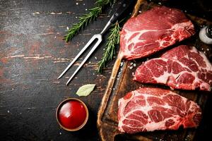 Raw pork steak on a wooden cutting board. photo