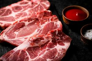 Raw pork steak on a stone board. photo