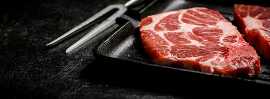 Raw pork steak on a grill pan. photo