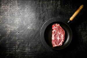 Raw pork steak in a frying pan. photo