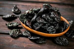 Prunes wooden plate on the table. photo