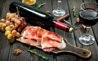 Traditional Spanish ham with grapes and red wine. photo