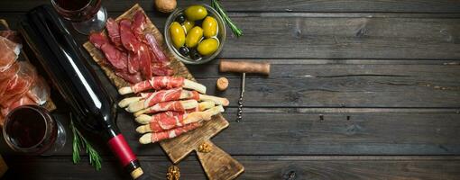 antipasto antecedentes.varios carne aperitivo con Olivos, jamon y rojo vino. foto