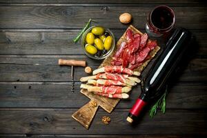 antipasto antecedentes.varios carne aperitivo con Olivos, jamon y rojo vino. foto