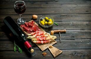 antipasto antecedentes.varios carne aperitivo con Olivos, jamon y rojo vino. foto