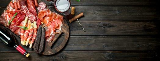 Antipasto background.Various assortment of meat snacks with red wine. photo