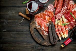 Antipasto background.Various assortment of meat snacks with red wine. photo