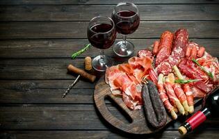Antipasto background.Various assortment of meat snacks with red wine. photo