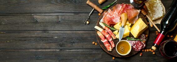 Antipasto background.Various meat and cheese snacks with red wine. photo