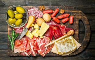 Antipasto background. Assortment of meat snacks on the Board with olives and Parmesan. photo