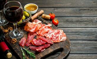 antipasto antecedentes. diferente carne meriendas con rojo vino. foto