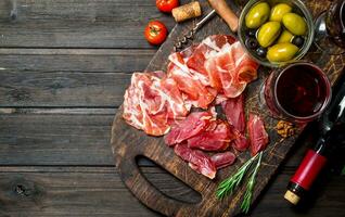 Antipasto background. Different meat snacks with red wine. photo