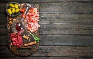 Antipasto background. Different meat snacks with red wine. photo