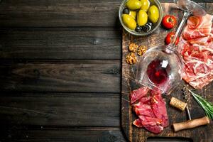 Antipasto background. Different meat snacks with red wine. photo