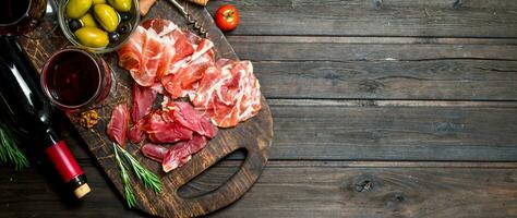 Antipasto background. Different meat snacks with red wine. photo
