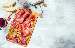 Antipasto background.Assortment of meat snacks with red wine. photo