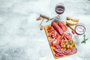 Antipasto background.Assortment of meat snacks with red wine. photo