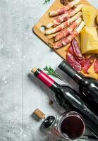 Antipasto background. Various meat and cheese snacks with red wine. photo