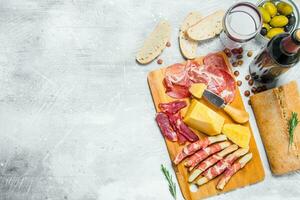 Antipasto background. Various meat and cheese snacks with red wine. photo