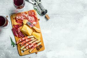 Antipasto background. Various meat and cheese snacks with red wine. photo