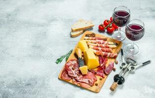 Antipasto background. Various meat and cheese snacks with red wine. photo